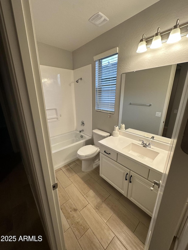 bathroom with wood finish floors, vanity, visible vents, toilet, and shower / bath combination