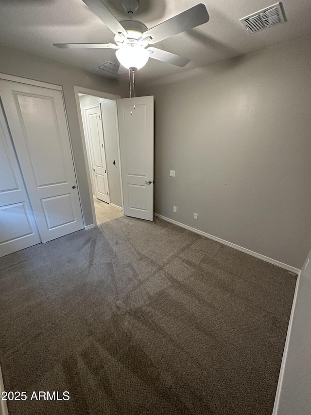 unfurnished bedroom featuring visible vents, baseboards, a closet, and carpet