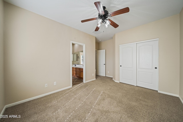 unfurnished bedroom featuring connected bathroom, a closet, ceiling fan, and carpet