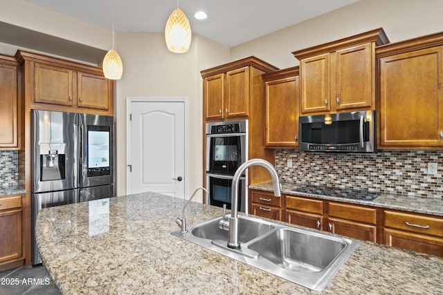 kitchen with sink, tasteful backsplash, decorative light fixtures, stainless steel appliances, and light stone countertops