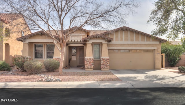 craftsman-style home with a garage, driveway, stone siding, and stucco siding