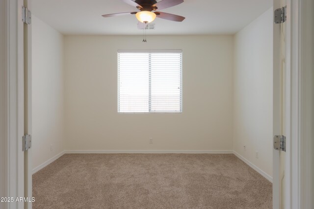 carpeted spare room with ceiling fan and baseboards