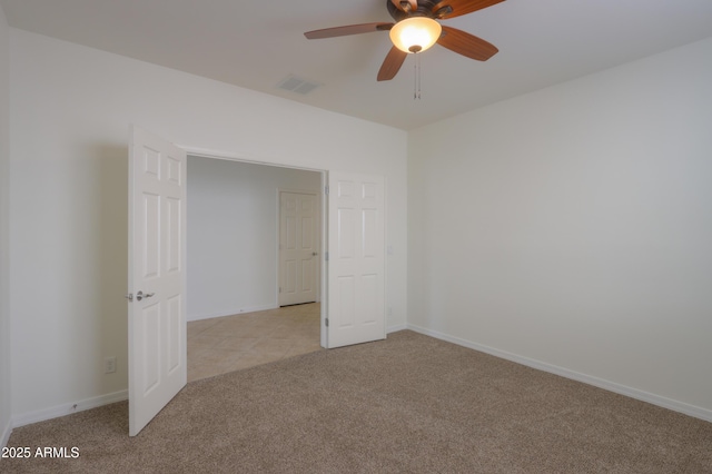 unfurnished bedroom featuring light carpet, ceiling fan, visible vents, and baseboards