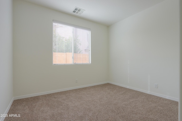 spare room featuring carpet floors, baseboards, and visible vents