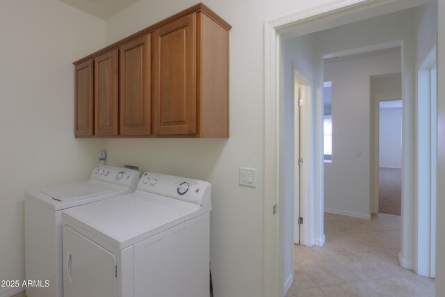 laundry area with cabinet space, light tile patterned floors, baseboards, and washer and clothes dryer