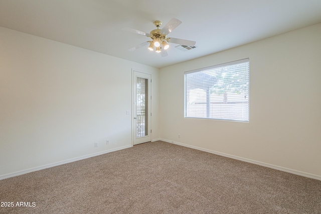 carpeted empty room featuring a ceiling fan, visible vents, and baseboards