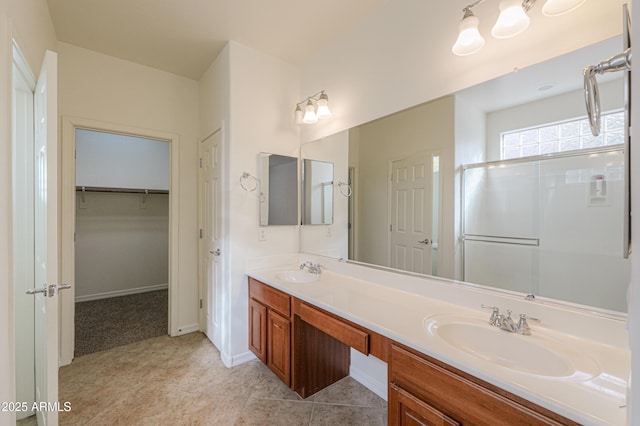 full bathroom featuring a stall shower, a walk in closet, a sink, and double vanity