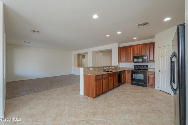 kitchen featuring black appliances, visible vents, and brown cabinets