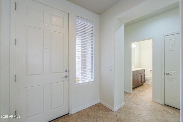 entrance foyer with light tile patterned floors and baseboards