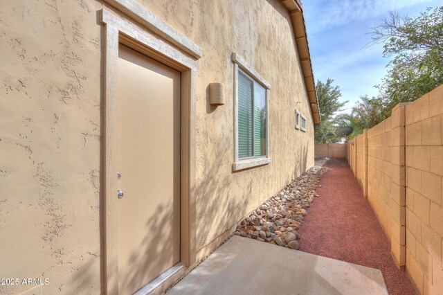 view of property exterior with fence and stucco siding