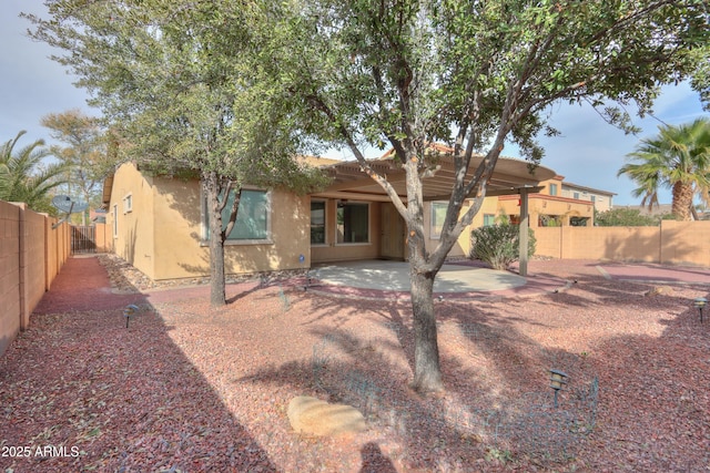 back of house featuring a patio, a fenced backyard, and stucco siding