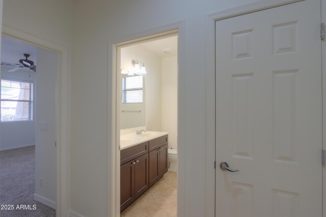 bathroom with toilet, a ceiling fan, vanity, tile patterned flooring, and baseboards