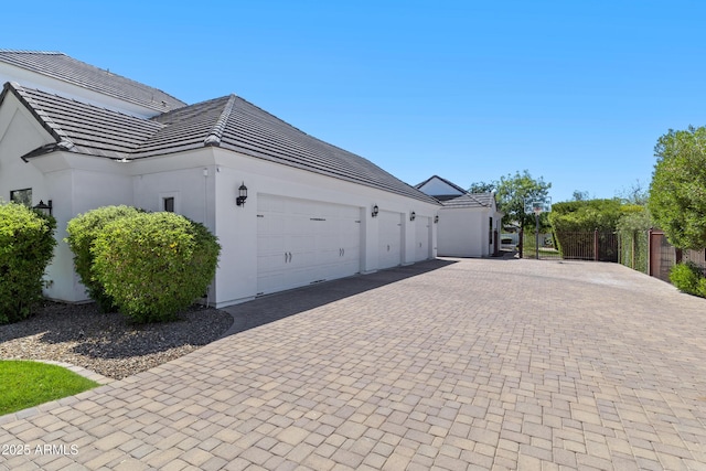 23902 S 202nd Ct, Queen Creek, AZ 85142 - view of home's exterior featuring a tile roof, decorative driveway, fence, a garage, and stucco siding