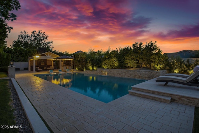 23902 S 202nd Ct, Queen Creek, AZ 85142 - pool at dusk featuring an outdoor pool, a storage structure, an outdoor structure, and a patio