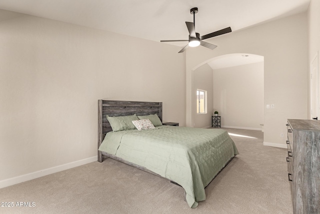 bedroom with arched walkways, carpet flooring, ceiling fan, and baseboards