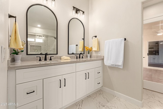 full bath featuring marble finish floor, baseboards, a walk in shower, and a sink