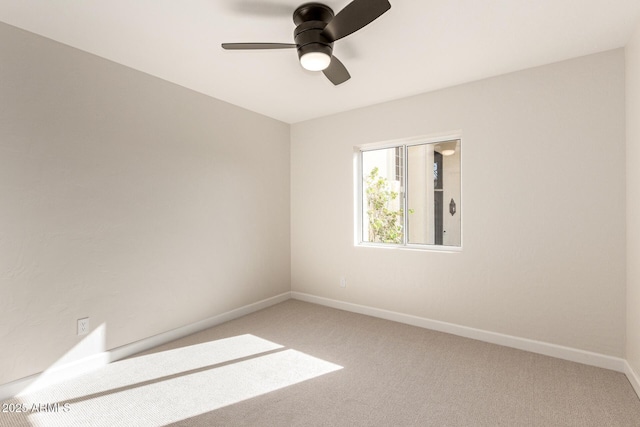 spare room featuring baseboards, ceiling fan, and light colored carpet