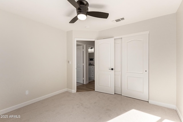 unfurnished bedroom with a closet, visible vents, carpet flooring, ceiling fan, and baseboards