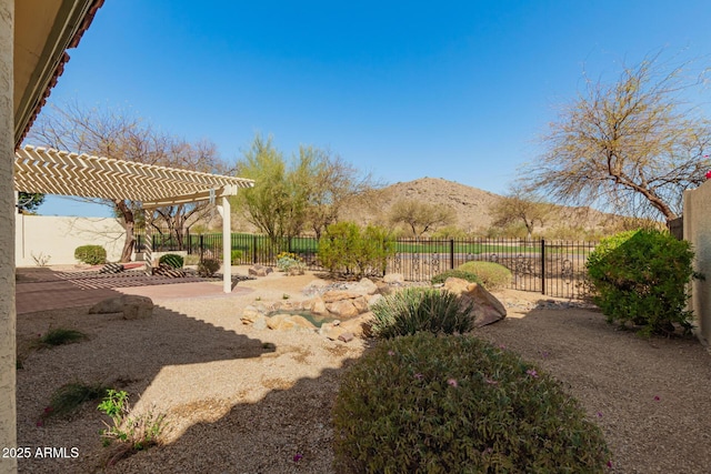 view of yard with a patio area, a fenced backyard, a mountain view, and a pergola