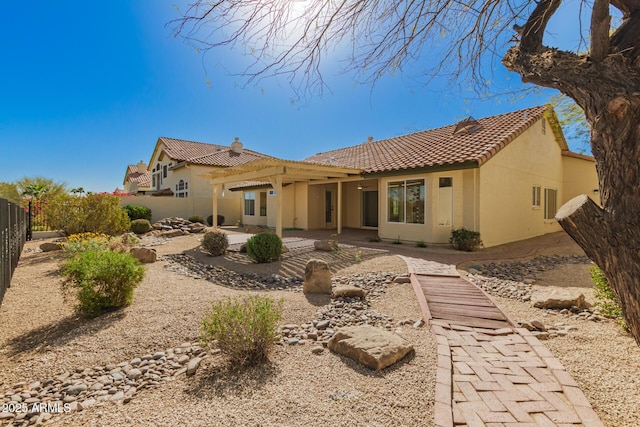 back of property with stucco siding, a patio area, fence, a pergola, and a tiled roof