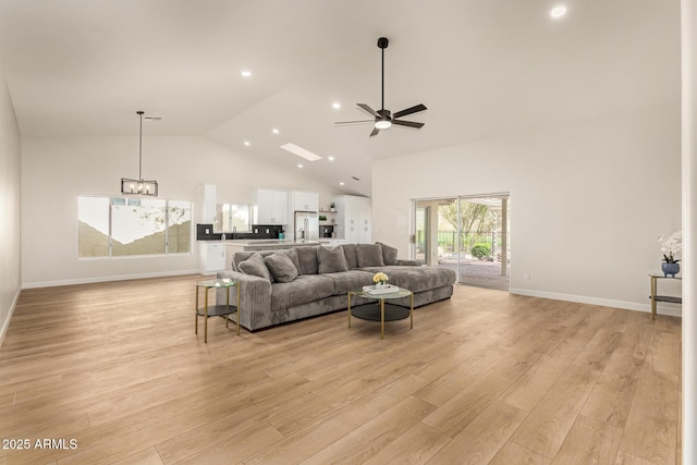 living room featuring baseboards, ceiling fan with notable chandelier, light wood-type flooring, high vaulted ceiling, and recessed lighting