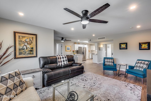 living room featuring ceiling fan and light wood-type flooring