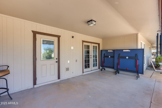 view of exterior entry with french doors and a patio area