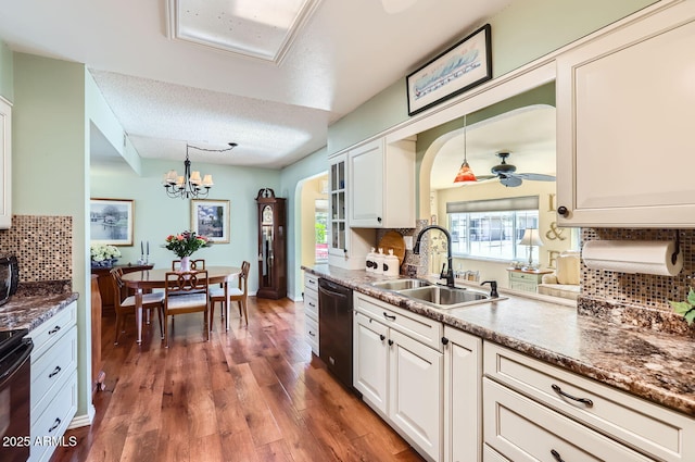 kitchen featuring sink, white cabinetry, dark hardwood / wood-style floors, black dishwasher, and pendant lighting