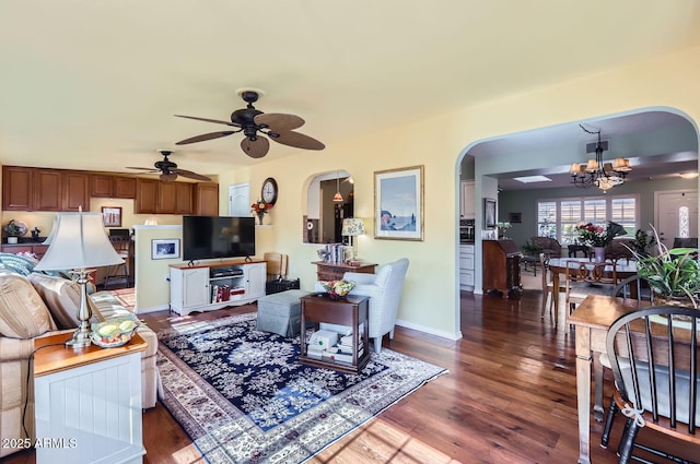 living room with dark hardwood / wood-style floors and ceiling fan with notable chandelier