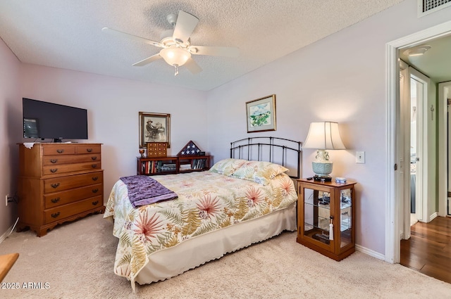 bedroom featuring ceiling fan, carpet floors, and a textured ceiling