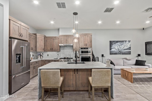 kitchen with appliances with stainless steel finishes, light wood-style flooring, and visible vents