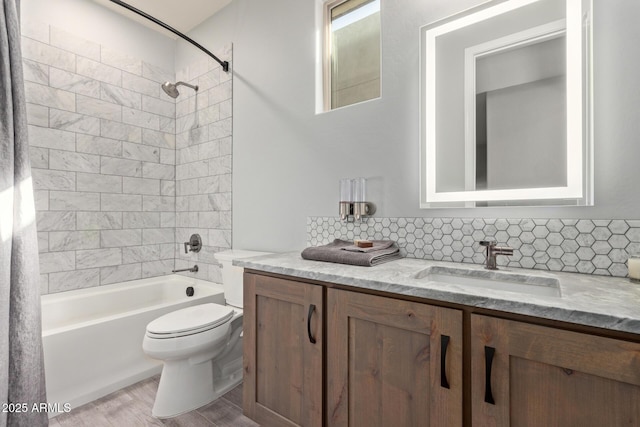 full bath featuring toilet, wood finished floors, vanity, backsplash, and shower / bathtub combination with curtain