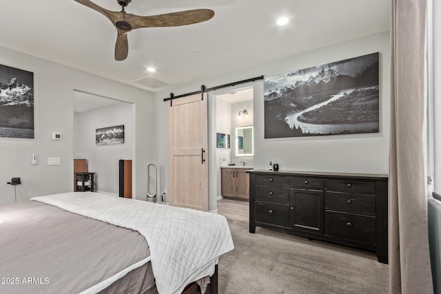 bedroom featuring light carpet, a barn door, visible vents, connected bathroom, and ceiling fan