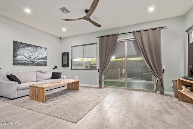 living area with baseboards, visible vents, ceiling fan, and wood finished floors