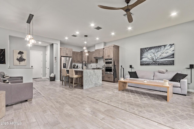 living area featuring light wood finished floors, visible vents, a ceiling fan, and recessed lighting