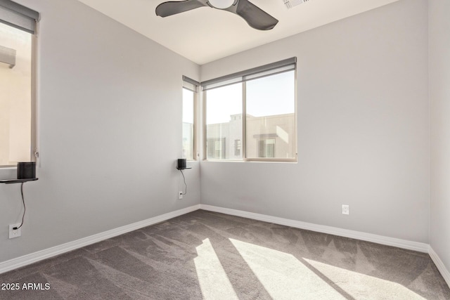 carpeted empty room featuring visible vents, ceiling fan, and baseboards