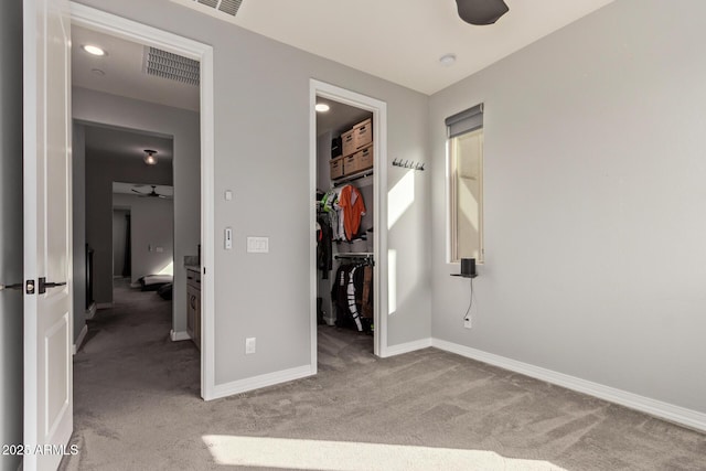 unfurnished bedroom featuring visible vents, baseboards, a spacious closet, a closet, and carpet