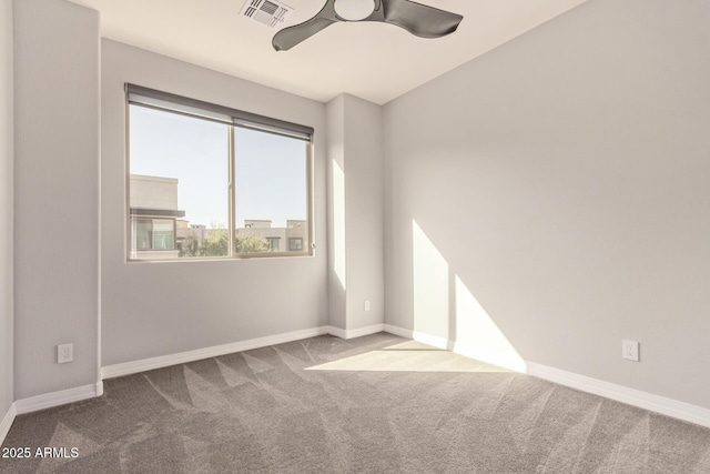 carpeted empty room featuring a ceiling fan, visible vents, and baseboards