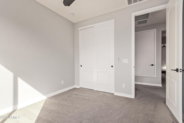 unfurnished bedroom with baseboards, a closet, visible vents, and carpet flooring