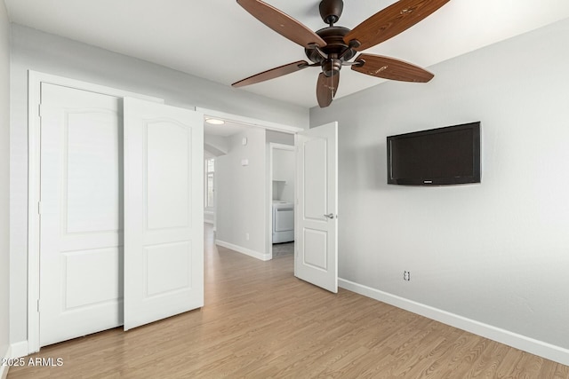 unfurnished bedroom with washer / clothes dryer, ceiling fan, and light wood-type flooring