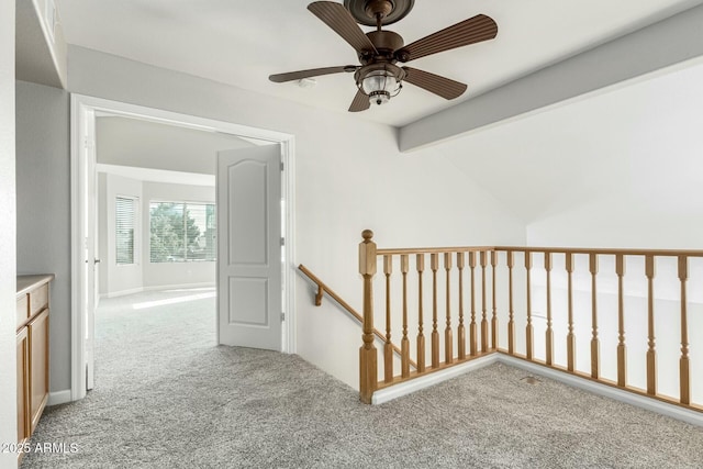 hallway with light carpet and vaulted ceiling with beams