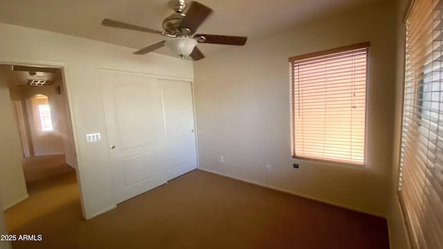 5374 N Ormondo Way, Litchfield Park, AZ 85340 - unfurnished bedroom featuring a closet, carpet floors, a ceiling fan, and arched walkways