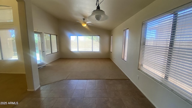 5374 N Ormondo Way, Litchfield Park, AZ 85340 - spare room with dark colored carpet, vaulted ceiling, dark tile patterned floors, and a ceiling fan