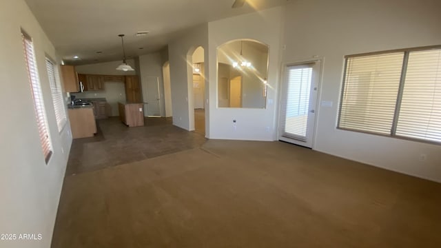5374 N Ormondo Way, Litchfield Park, AZ 85340 - unfurnished living room featuring arched walkways, vaulted ceiling, and carpet flooring