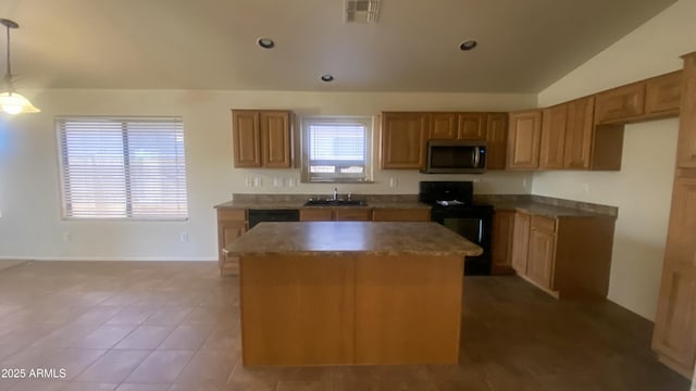 5374 N Ormondo Way, Litchfield Park, AZ 85340 - kitchen with stainless steel microwave, black range with electric stovetop, a center island, vaulted ceiling, and brown cabinetry