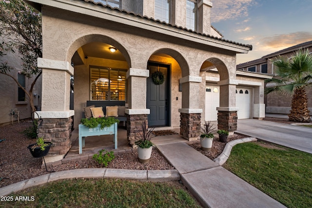 3773 E Stampede Dr, Gilbert, AZ 85297 - exterior entry at dusk with a porch, stucco siding, and concrete driveway