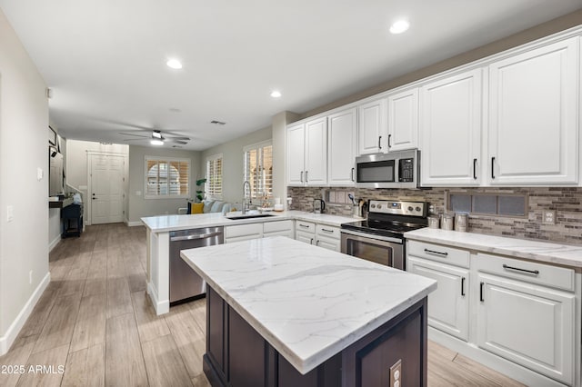 3773 E Stampede Dr, Gilbert, AZ 85297 - kitchen featuring appliances with stainless steel finishes, a sink, a peninsula, a center island, and backsplash