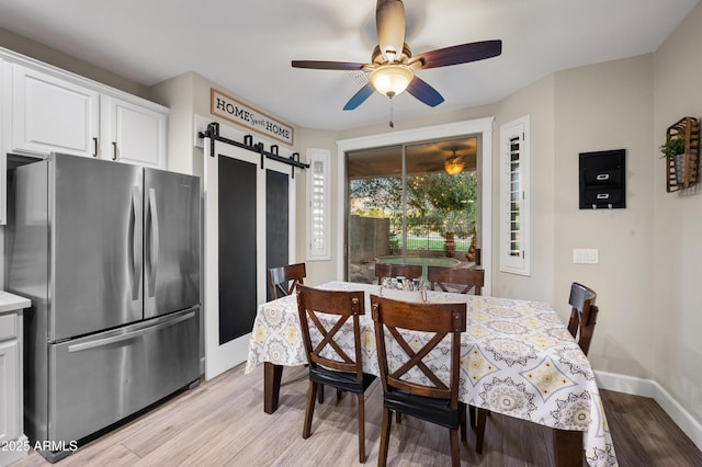 3773 E Stampede Dr, Gilbert, AZ 85297 - dining space with a barn door, light wood-style flooring, a ceiling fan, and baseboards