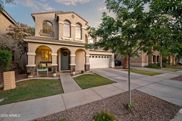 3773 E Stampede Dr, Gilbert, AZ 85297 - mediterranean / spanish house featuring a porch, stucco siding, driveway, stone siding, and a garage