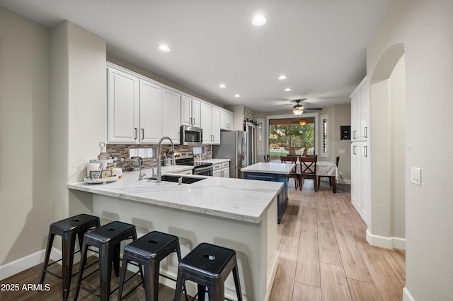 3773 E Stampede Dr, Gilbert, AZ 85297 - kitchen with stainless steel appliances, a kitchen island, baseboards, a sink, and a peninsula